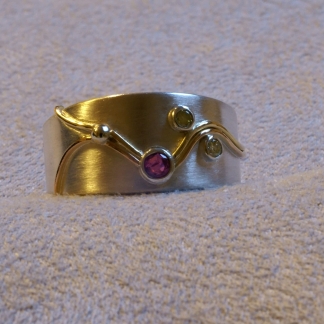 Fingerring mit persönlicher Geschichte aus 925/-Silber und 585/-Gelbgold mit einem Rubin und Brillanten