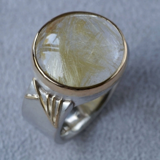 Fingerring aus 925/-Silber und 750/-Gelbgold mit einem Rutilquarz in einer Zargenfassung